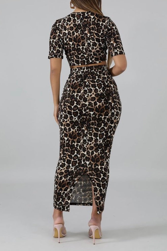 Featuring a body-hugging design with a round neckline, short sleeves, and matching midi skirt, leopard print