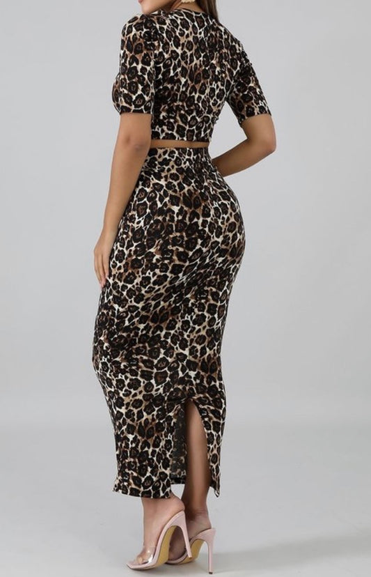 Featuring a body-hugging design with a round neckline, short sleeves, and matching midi skirt, leopard print